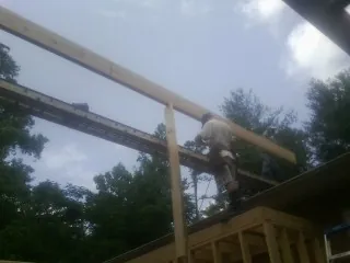 Carpenter setting a ridge beam over a new addition frame — Ice Dam Removal by Roofing Brothers in Chokoloskee